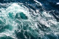 Abstract background. The waves of the sea water meet with underwater pointed rocks, forming whirlpools.