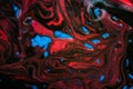 Abstract background with waves and streaks of blue, black and red colors. Natural background of oil and watercolor paints with