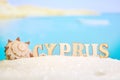 Abstract beach sand seashell on a blurred sea background with boat and letters. Cyprus is one of the most popular resorts in the Royalty Free Stock Photo