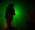 abstract black background with green color lasers and a woman figure silhouette.