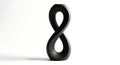 Abstract black infinity symbol sculpture reflecting modern design principles and endless possibilities isolated on white Royalty Free Stock Photo