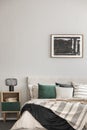 Black oil painting in frame on empty beige wall of cozy bedroom Royalty Free Stock Photo