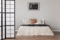 Abstract black oil painting in frame on empty beige wall of cozy bedroom Royalty Free Stock Photo