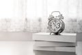Abstract Black and White image of alarm clock put on stack of books on wooden table. Royalty Free Stock Photo