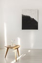 Abstract black and white painting on empty white wall with wooden coffee table with candles