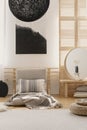 Abstract black and white painting on the wall in bright bedroom interior with futon bed and mirror on bedside table Royalty Free Stock Photo