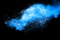 Abstract blue dust explosion on black background.