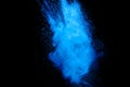 Abstract blue dust explosion on black background. Freeze motion of blue particles splashing. Painted Holi