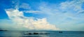 Abstract blue sky with clouds and beautiful sea open water and rocks background. Royalty Free Stock Photo