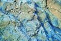 Abstract blue yellow brown background. Colorful rock texture. Cracked layered mountain surface. Close-up. Royalty Free Stock Photo