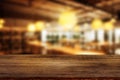 Empty space wooden table top with abstract blurry image of coffee shop or cafe restaurant in background.