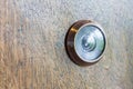 Abstract blur photo of old lens peephole on wooden door background.