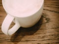 abstract blur : white coffee cup with hot cappuccino coffee inside put on wooden table background Royalty Free Stock Photo