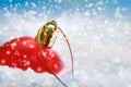 Abstract blured snowy background, red Christmas ball lies in the snow