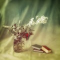 Abstract blurred background of colorful picturesque bouquet of spring flowers in glass vase near books. Romantic concept