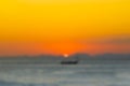 Abstract blurred background Wooden fishing boat sailing on the sea, against the backdrop of the sunset and the mountains Royalty Free Stock Photo