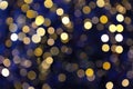 Abstract blurred bokeh background with Christmas tree garland warm yellow lights in city center. Royalty Free Stock Photo