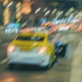 Abstract blurred evening traffic. Close-up of stopped yellow taxi. Urban modern background