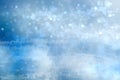 Abstract blurred festive winter christmas or Happy New Year background with shiny blue and white bokeh lighted snow landscape. Royalty Free Stock Photo