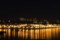 Abstract blurred illuminated city with reflection in the lake. Night defocused background with bokeh Royalty Free Stock Photo