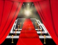 Abstract blurred image. Red carpet with stairs between two rope barriers and flash light. Scene illuminated by a spotlight. Royalty Free Stock Photo