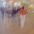 Abstract blurred image of unrecognizable silhouettes of people walking in city street in evening, shopping. Urban modern Royalty Free Stock Photo