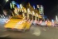 Abstract blurred image of yellow taxi, urban street night traffic with bokeh lights, night time, for background use Royalty Free Stock Photo