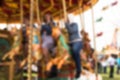 Abstract blurred people riding on carousel horse