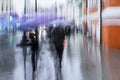 Abstract blurred people under the umbrellas. Rainy evening in the city street at autumn, blurred motion. Seasons