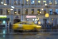 Abstract blurred rainy evening . Close-up of stopped yellow taxi. Urban modern background