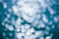 Abstract blurred shining sunlight bokeh on blue sea water background. Royalty Free Stock Photo