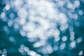 Abstract blurred shining sunlight bokeh on blue sea water background. Royalty Free Stock Photo