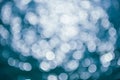 Abstract blurred shining sunlight bokeh on blue sea water background. Royalty Free Stock Photo