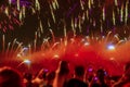 Abstract blurred silhouettes of unrecognizable crowd of people with their backs to us watching fireworks together