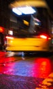 Abstract blurred soft focus night scene with neon lights and a yellow city bus in motion blur Royalty Free Stock Photo