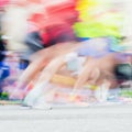 Abstract blurred sport background of colorful running feet and legs of runners during marathon on city streets. For Royalty Free Stock Photo