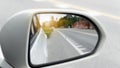 Abstract and blurred of wing mirror of white car on the road heading towards the goal of the trip. Royalty Free Stock Photo
