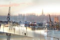 Abstract blurry scene in the port of Lubeck with boats, cranes and a waiting person in the evening sun, long term and double