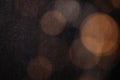 Abstract bokeh texture background with orange and brown circles from a garland on a dark antique backdrop close up. Circles of Royalty Free Stock Photo