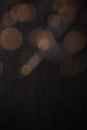 Abstract bokeh texture background with orange and brown circles from a garland on a dark antique backdrop close up. Circles of Royalty Free Stock Photo