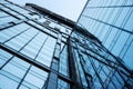 Abstract bottom view of a modern glass building with reflections and sky. Urban geometry, modern architecture, abstract