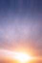 Abstract bright sun at sunset on the background of clouds and blue sky Royalty Free Stock Photo