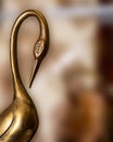 Abstract Bronze Crane metal Heron with bend neck against blurry brown background. Vintage Art