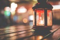Abstract candle lantern light on wood table in blur bokeh pub re