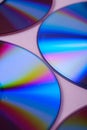 Abstract CD DVD compact disc disk dispersion refraction reflection of light colors texture on pink background close up