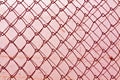 abstract chain link fence texture against grungy color wall. Royalty Free Stock Photo