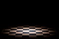 Abstract chessboard on dark background lighted with snoot Royalty Free Stock Photo