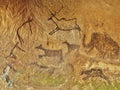 Abstract children art in sandstone cave. Black carbon paint of human hunting on sandstone wall Royalty Free Stock Photo