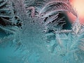 Abstract Christmas background. Ice crystals on frozen window glass. Frost drawing. Winter season theme. Dark turquoise and red Royalty Free Stock Photo