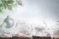 Abstract christmas background with silver bauble on fir and empty snowy table